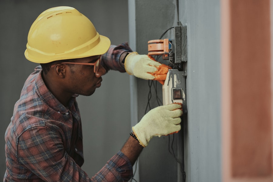 Electrician in protective gear wiring an electrical panel